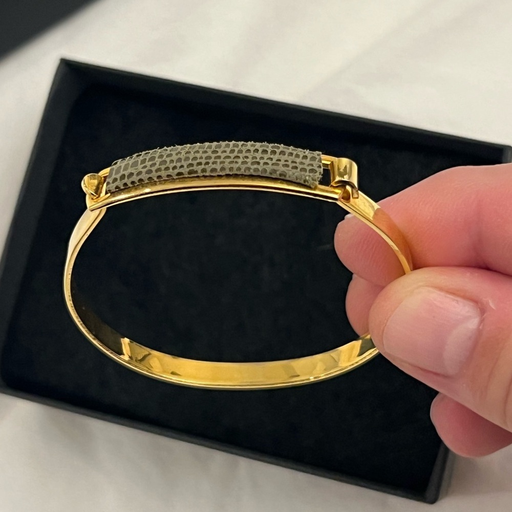 Gold tone AV Max NYC bangle with green lizard accent.